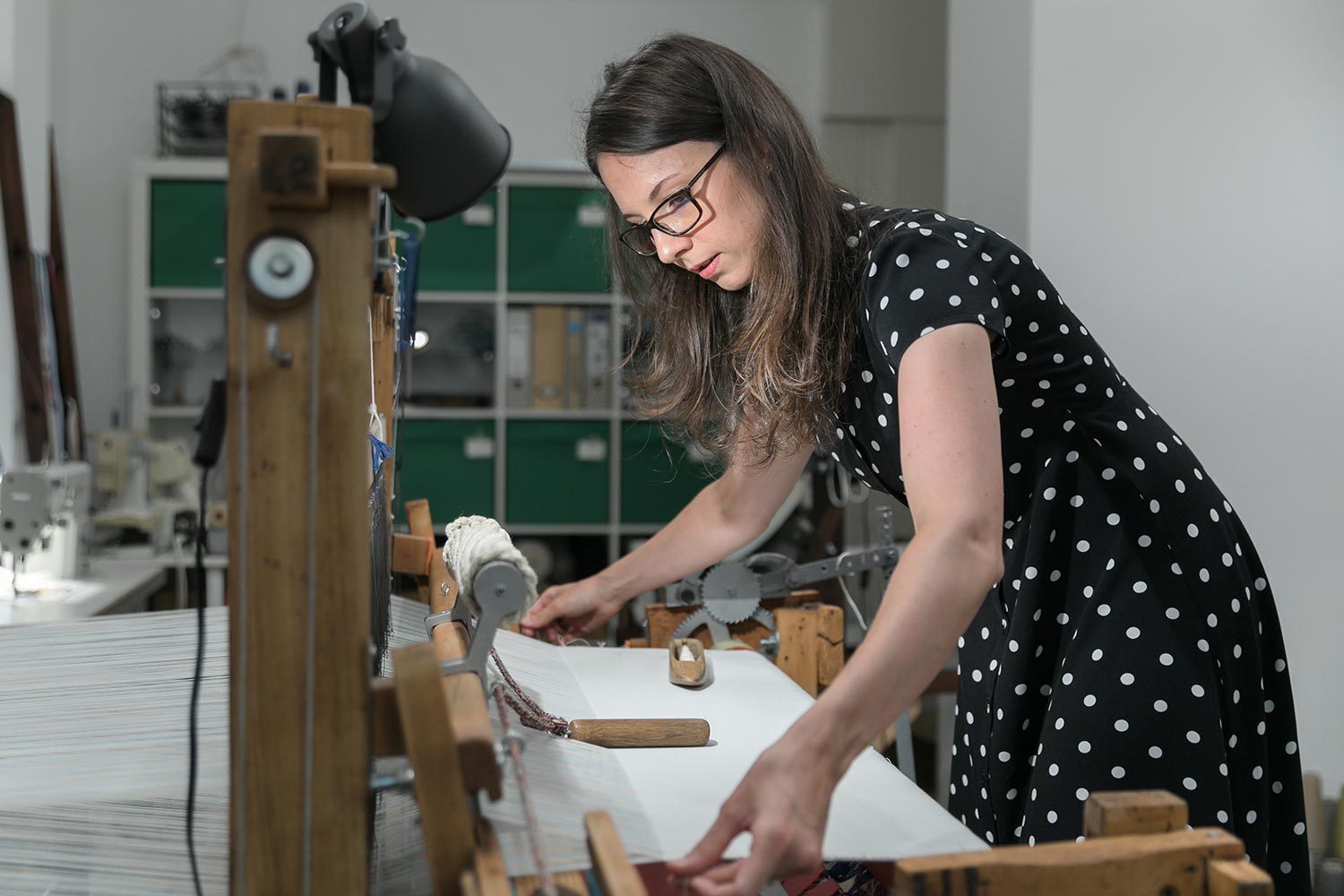Krisztina Vandor is weaving at her studio in a polka dot dress