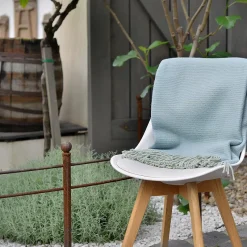 kék pléd egy kertben székre terítve