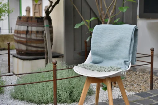 kék pléd egy kertben székre terítve