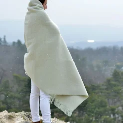 nő hóesésben fehér plédbe burkolózva
