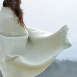 nő panorámával a hóesésben fehér plédbe bukolózva