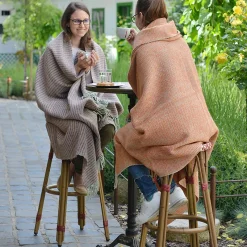 nők kártolt gyapjú plédbe takarózva kávéznak
