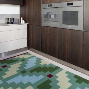 handwoven green patterned kilim type wool rug at a kitchen