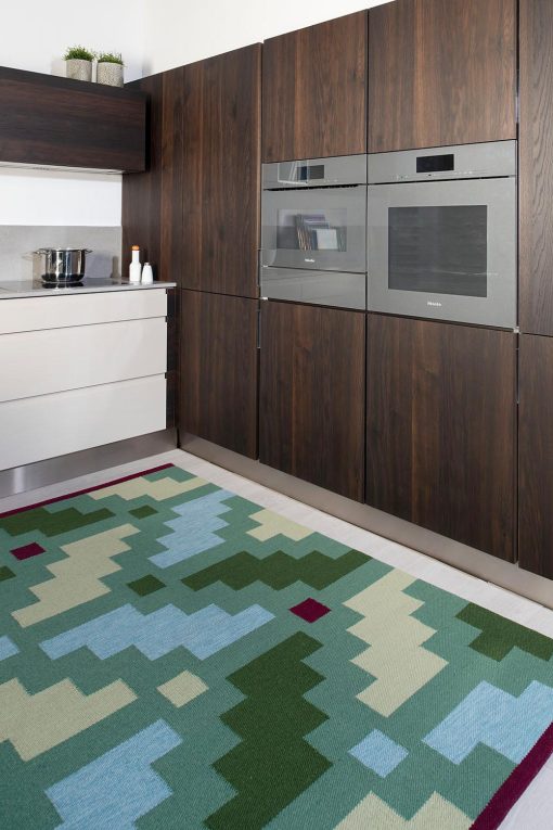 handwoven green patterned kilim type wool rug at a kitchen
