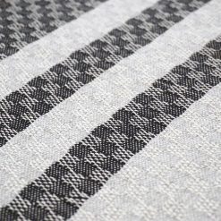 detail of a handwoven cushion with navy blue and grey stripes