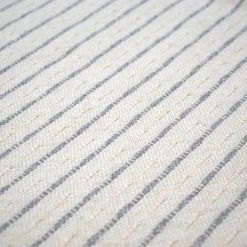 detail of a white and grey striped throw pillow