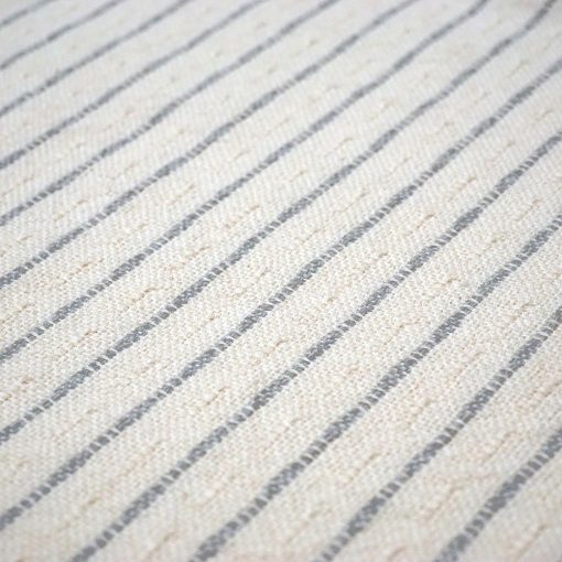 detail of a white and grey striped throw pillow