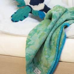 zöld takaró gyerek ágyra terítve